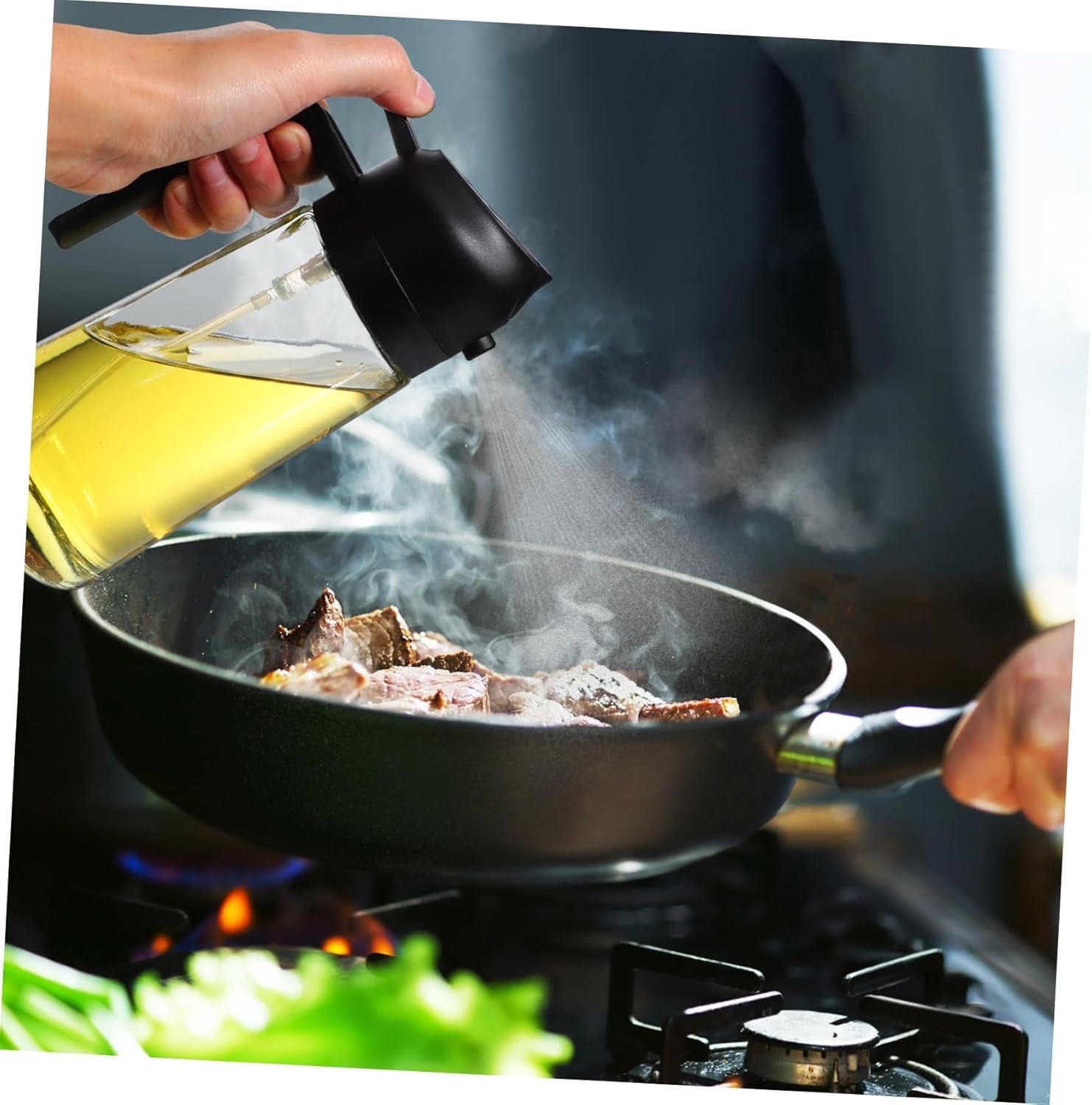 Oil sprayer being used over a hot pan